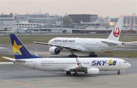 福岡空港に着陸したスカイマーク機（手前）と離陸を待つ日本航空機＝２１日午後