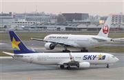 福岡空港に着陸したスカイマーク機（手前）と離陸を待つ日本航空機＝２１日午後