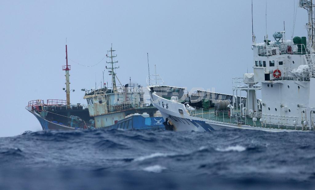 小笠原諸島・父島（東京都小笠原村）の南１６キロの領海内で中国のサンゴ密漁漁船（左）を追跡する海上保安庁の巡視船「するが」（右）＝２０１４年１１月９日、小笠原諸島・父島（東京都小笠原村）の南１６キロ領海内（大山文兄撮影）