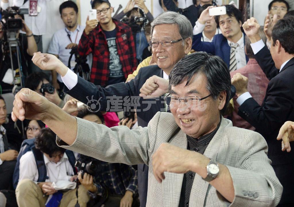 沖縄県知事選で当選を確実にし、米軍普天間飛行場の名護市移設反対でタッグを組む稲嶺進名護市長（手前）とカチャーシーを踊る翁長雄志（おなが・たけし）氏＝２０１４年１１月１６日、沖縄県那覇市（共同）