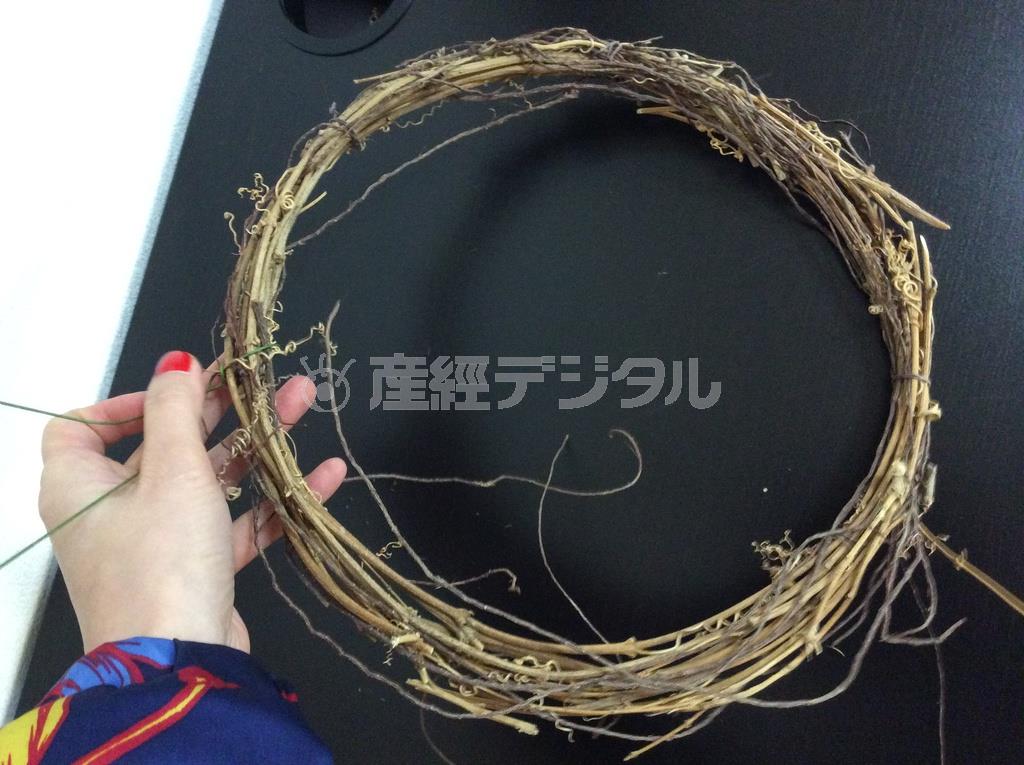 （手順１）資材屋で市販されているツルのリース型に、ドアに吊るためのワイヤーを取付ける（花千代さん提供）