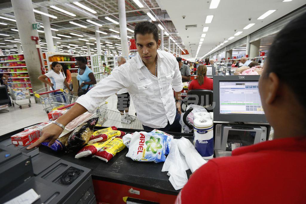 ベネズエラの首都カラカスのスーパーで指紋判定器に指を添える男性客＝２０１４年９月２５日（ロイター）