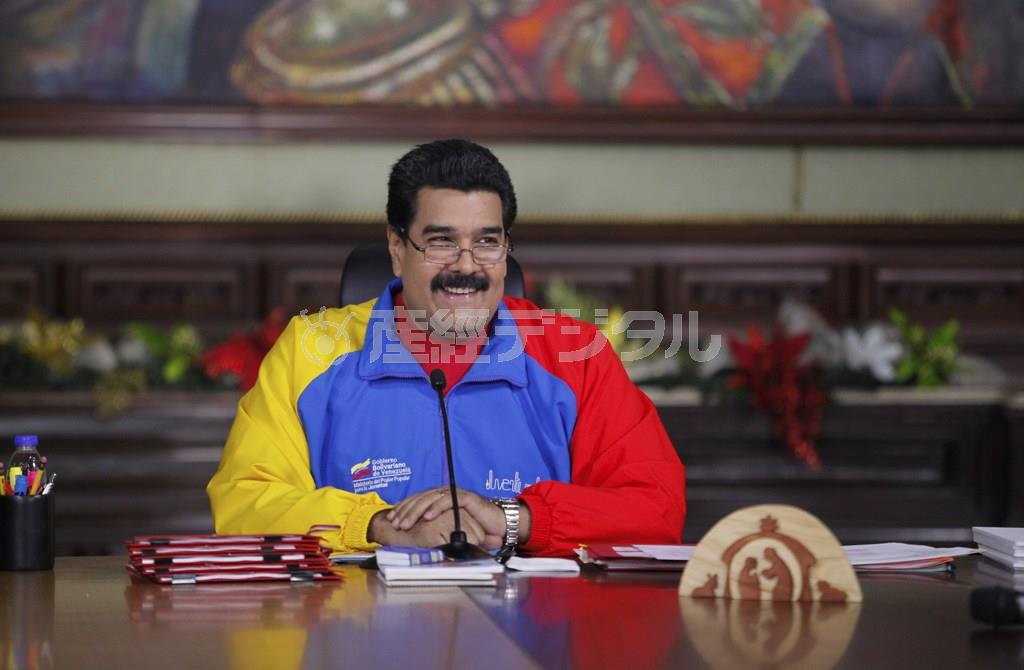 居並ぶ閣僚を前に、「メリークリスマス作戦」の発動を打ち出し、満面の笑みを浮かべるベネズエラのマドゥロ大統領。昨年は同様の作戦で支持率を回復させることができたが…＝２０１４年１１月１３日、ベネズエラ・首都カラカスのミラクロレス宮殿（ロイター）