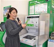 ゆうちょ銀のＡＴＭでお金を引き出すデモンストレーションを行う女優の原日出子さん＝２６日、東京都千代田区のファミリマート一番町店（山口暢彦撮影）