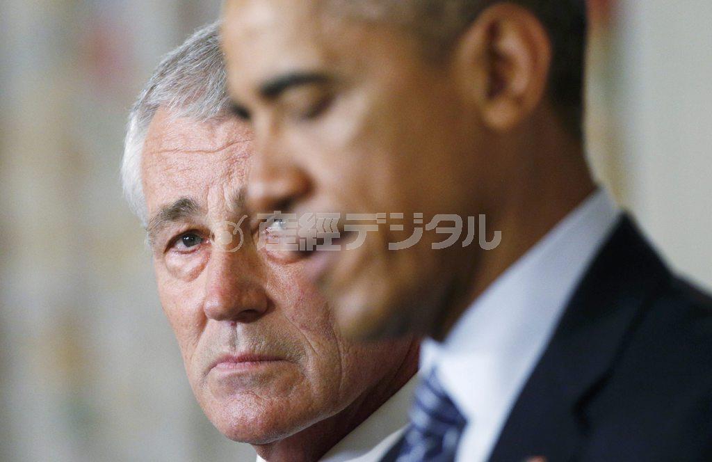 バラク・オバマ米大統領（右）が自身の更迭を発表する様子をみつめるチャック・ヘーゲル米国防長官＝２０１４年１１月２４日、米国・首都ワシントン・ホワイトハウス（ロイター）