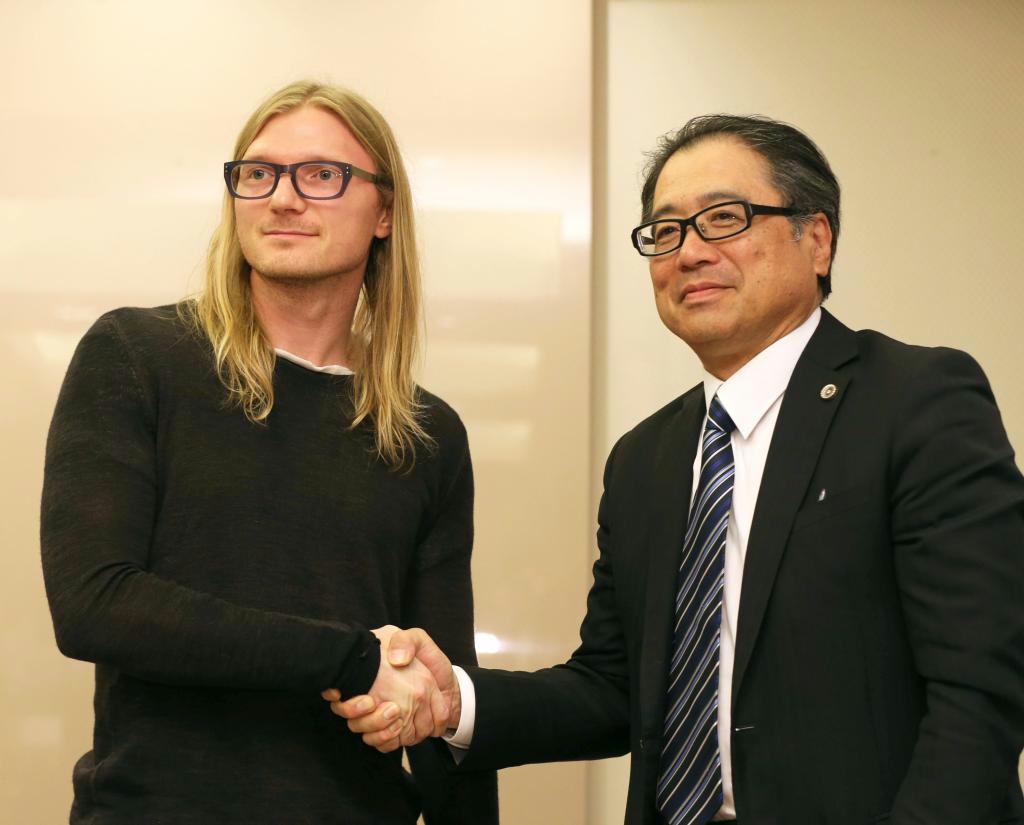 記者会見で握手するクラケンのジェシー・パウエルＣＥＯ（左）とマウントゴックス破産管財人の小林信明弁護士＝２６日、東京都千代田区