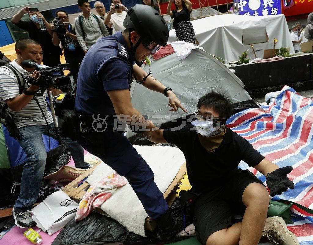 香港の九竜地区の繁華街モンコック（旺角）で、デモ参加者を強制的に排除する警官。当局側はバリケードやテントの撤去をほぼ完了した＝２０１４年１１月２６日、中国（ロイター）