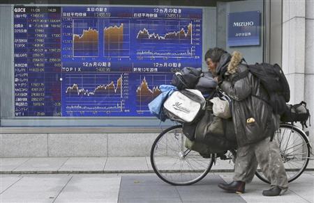 ２８日の日経平均株価は２１１円高で取引を終了。株価を示すボードの前を行く男性。１１月は１０００円を超える上げ幅となった（ＡＰ）