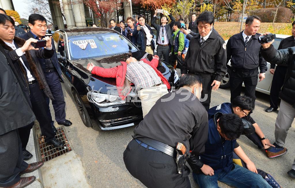 初公判を終え、ソウル中央地裁を後にする際、加藤達也前ソウル支局長を乗せた車は抗議デモ団に囲まれ、生卵を投げつけられるなどの妨害行為にあった＝２０１４年１１月２７日、韓国・首都ソウル（大西正純撮影）