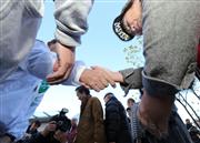 ＪＲいわき駅前で有権者らと握手する候補者（左）＝２日午前、福島県いわき市