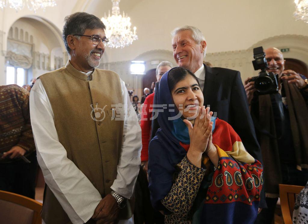 記者会見の会場に到着したマララ・ユスフザイさん（右手前）と共同受賞者のカイラシュ・サトヤルティさん（左）。後方はノルウェー・ノーベル賞委員会のトールビョルン・ヤーグラン委員長＝２０１４年１２月９日、ノルウェー・首都オスロ（ロイター）