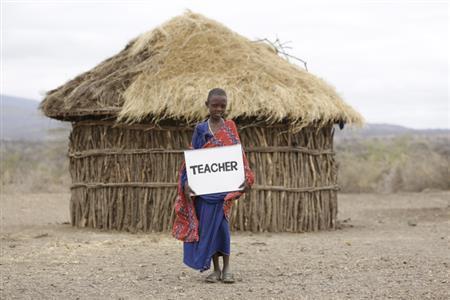 「夢は学校の先生」。撮影用に書いた「夢」を手にしてたたずむメアリーちゃん＝２０１４年８月３日、タンザニア（ワールド・ビジョン・ジャパン撮影）