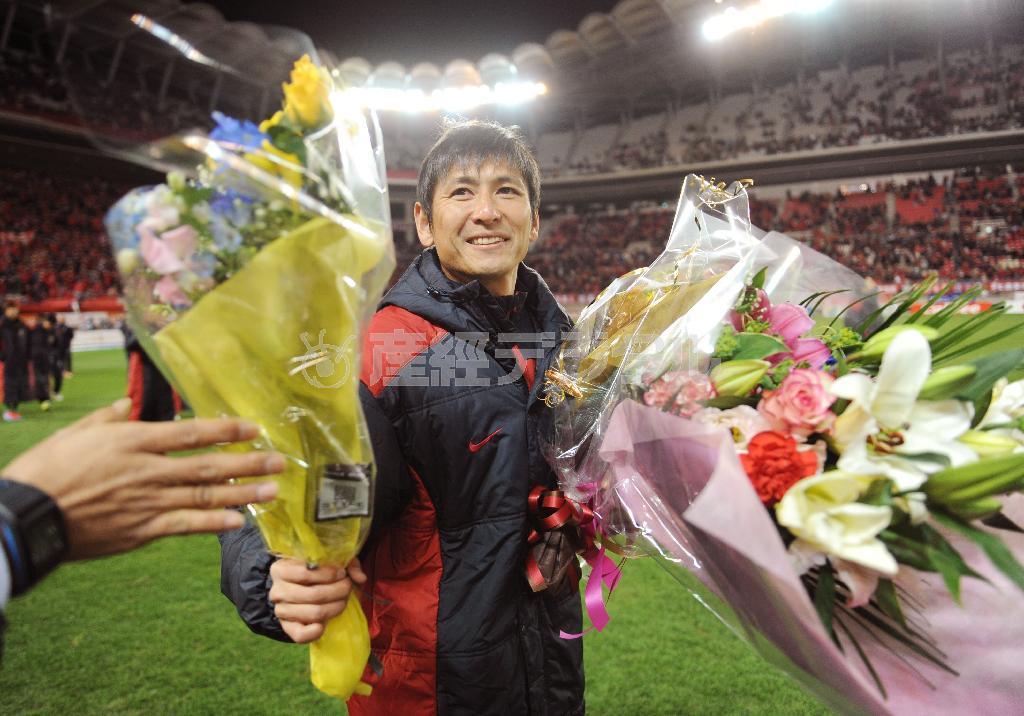 引退セレモニーを終え、サポーターからの花束を手にする鹿島の中田浩二＝２０１４年１２月、茨城県鹿嶋市の茨城県立カシマサッカースタジアム（共同）