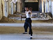 アフガニスタンの首都カブールの廃墟で、ヌンチャクを持ちポーズを決めるアッバス・アリザダさん。ネット上では、「ブルース・リーの生まれ変わりだ」などと大反響を呼んでいる＝２０１４年１２月９日、アフガニスタン・首都カブール（ロイター）