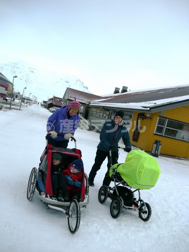 スピッツベルゲン島ロングイヤービエンのメーンストリートを散歩する親子。母親たちによると、北極圏は意外にも家族の絆が強まり、子育てに最適なのだという＝２０１４年１０月１８日、ノルウェー・スバルバル諸島（内藤泰朗撮影）