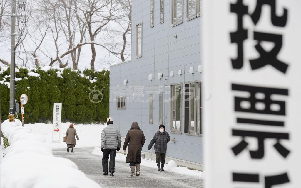 雪が舞う中、衆院選の投票所に向かう有権者＝２０１４年１２月１４日午後、山形県鶴岡市（共同）