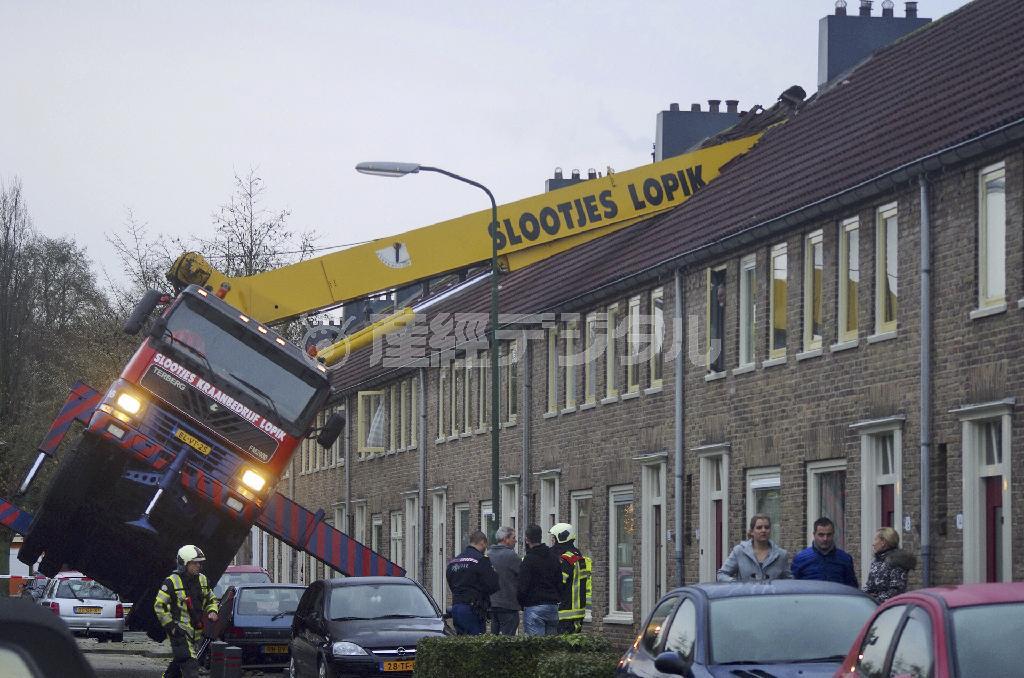 プロポーズしようとした男性の乗ったクレーン車が傾き、隣家の屋根を破壊した＝２０１４年１２月１３日、オランダ・エルセルスタイン（ＡＰ）