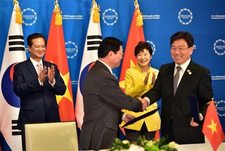 韓国とのＦＴＡ交渉妥結に関する合意書の調印式を見守るベトナムのグエン・タン・ズン首相（左）と韓国の朴槿恵大統領（右から２人目）＝１０日、韓国・釜山（ＡＰ）