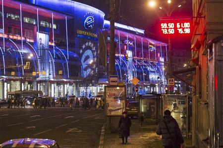 通過ルーブルが急落した１５日、為替レートの掲示板下を通行するモスクワの人々（ＡＰ）