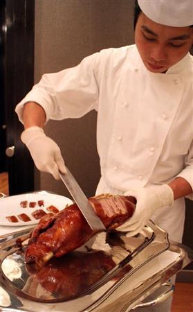 広東料理「雅閣（ヤグ）」の客席で北京ダッグを振る舞うシェフ＝２０１４年１１月１２日、台湾・台北市（佐野領撮影）