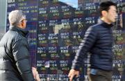 １９日、都内の証券会社店頭で株価ボードを見る男性。この日の日経平均株価は大幅続伸した（ＡＰ）