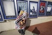 公開中止を受け、「ザ・インタビュー」の宣伝ポスターをはがして運び去る米ジョージア州アトランタの映画館チェーン、カーマイク・シネマズの係員＝２０１４年１２月１７日（ＡＰ）