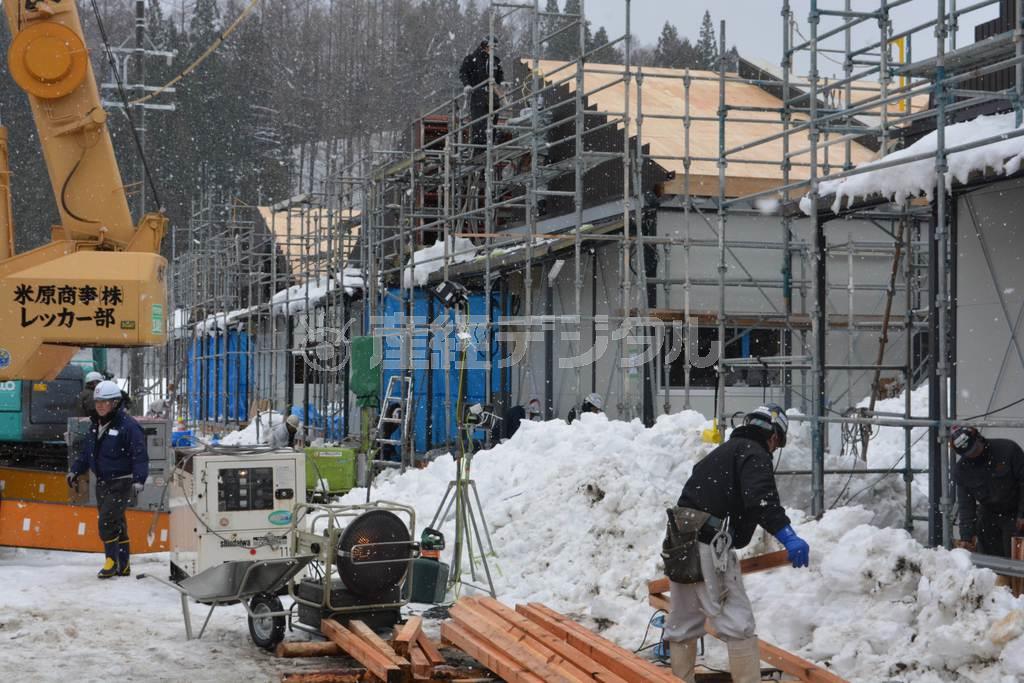 降雪の中、仮設住宅の工事現場では作業員が黙々と作業にあたっていた＝２０１４年１２月２１日、長野県北安曇郡白馬村（三宅真太郎撮影）