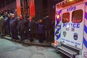 パトカーの中で銃撃され、死亡した警察官２人の遺体を載せた警察車両の車列を敬礼とともに見送るニューヨーク市警の職員たち＝２０１４年１２月２０日、米ニューヨークのブルックリン地区（ロイター）