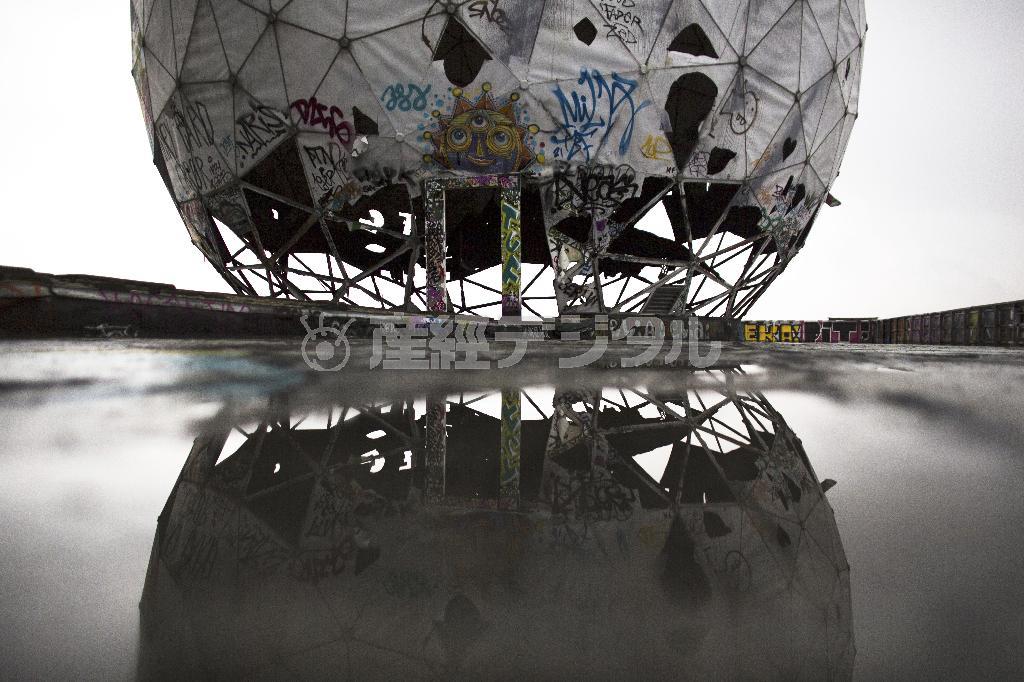 アメリカ国家安全保障局の防諜用アンテナ。ゴルフボール形のカバーのついたこのアンテナは、１９９０年代初頭まで使用されていたが、廃墟となり、水たまりにその姿を映し出している。現在はガイドツアーでのみ訪問することができるという＝２０１４年１１月２２日、ドイツ・首都ベルリン（ＡＰ）