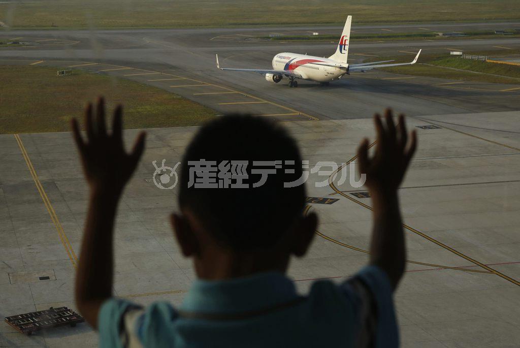 クアラルンプール国際空港でマレーシア航空機を見送る少年。今年３月８日にこの空港から乗員乗客２３９人を乗せて北京に向け飛び立った３７０便はいまも行方不明のままだ＝２０１４年１２月８日、マレーシア・首都クアラルンプール（ロイター）