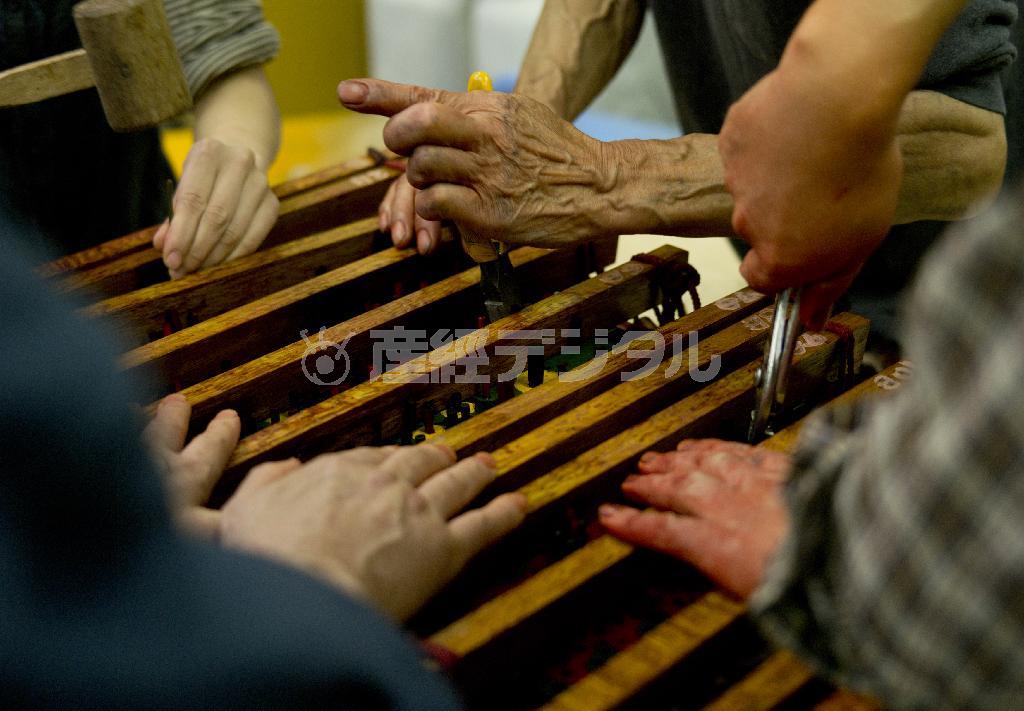 版木に栓をする。福田伝次さんを含む、先代からのベテラン職人４人のチームで復元に挑んでいる。美しいものをつくり出す、手や道具それ自体も美しい＝２０１３年１０月１５日（井浦新さん撮影）