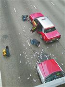 ２４日午後、香港・ワンチャイの道路上に散乱した紙幣を拾うタクシーの乗客ら（香港紙、蘋果日報のウェブサイトから）
