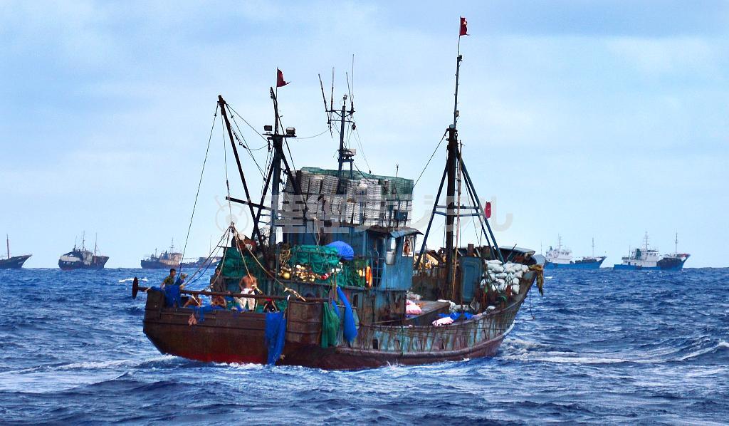 写真は９月２２日に小笠原諸島嫁島の沖合約５キロ付近で目撃された不審船。赤い旗を掲げ、背後にも複数の船が見える＝２０１４年、東京都小笠原村（父島の住民提供）