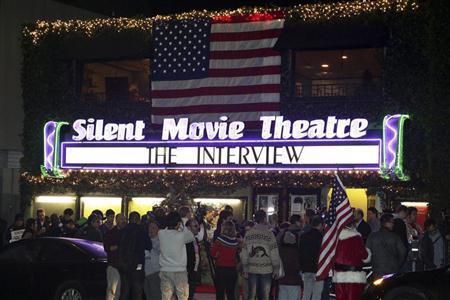 全米で最初にコメディー映画「ザ・インタビュー」が公開された映画館「サイレント・ムービー・シアター」に詰めかけた観客たち。入り口には米国の国旗である星条旗が掲げられた＝２０１４年１２月２４日、米カリフォルニア州ロサンゼルス（ロイター）