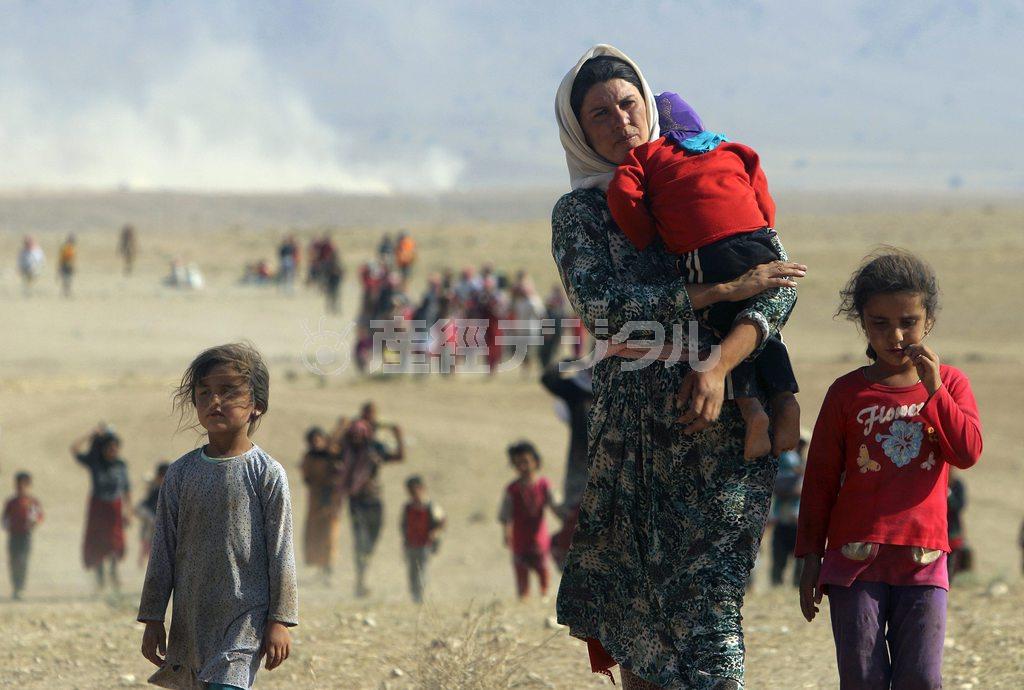 シリア国境に近いイラクの街シンジャルの周辺を逃げ惑うヤジディの女性と子供たち。原油の密輸や一部産油国の支援で活動資金を調達し、イスラム過激派にイラクの旧フセイン政権の軍関係者が合流したイスラム国は強い軍事力を持ち、瞬く間に勢力を拡大した＝２０１４年８月１１日（ロイター）