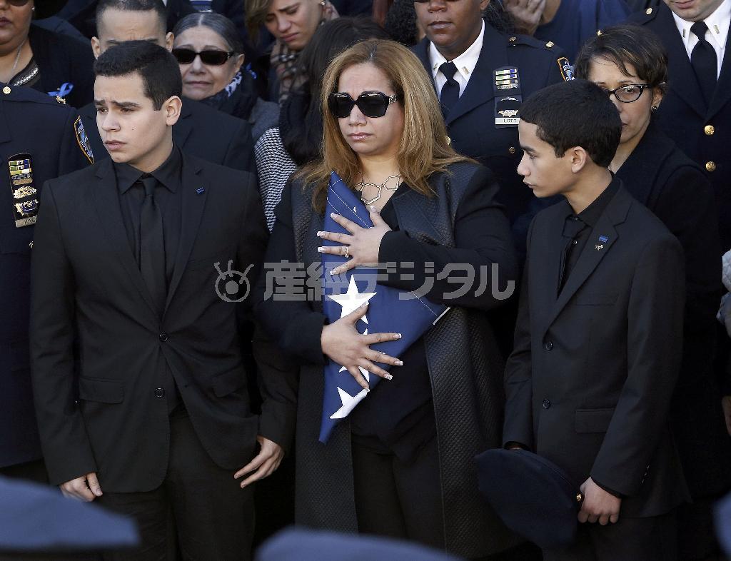 ラファエル・ラモス氏の葬儀に出席した妻のマリッツァ・ラモスさん（中央）と２人の息子たち＝２０１４年１２月２７日、米ニューヨーク（ＡＰ）