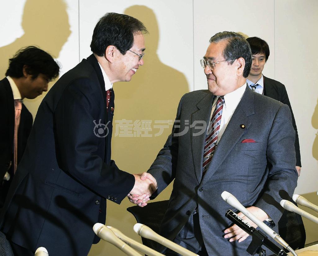 ２０１５年度税制改正大綱を決定し、記者会見後に握手する自民党の野田毅（たけし）税調会長（右）と公明党の斉藤鉄夫税調会長＝２０１４年１２月３０日午後、衆院第２議員会館（共同）