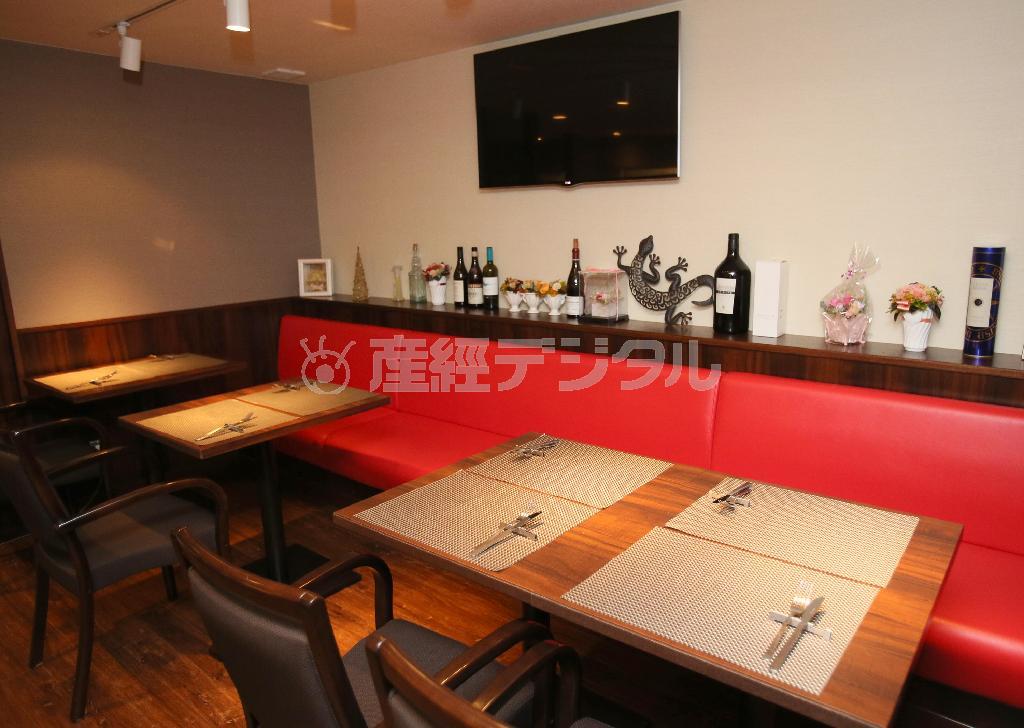 シックな空間に赤いソファが印象的。壁の大型スクリーンモニターはイタリアに関連した映画が無声・字幕入りで上映されている＝２０１４年１２月１０日、京都市下京区（志儀駒貴撮影）