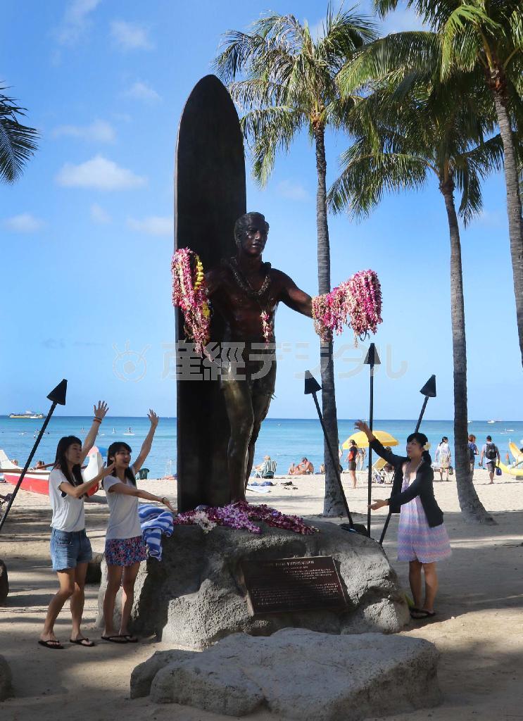 ワイキキのカラカウア通りにあるデューク・カハナモク像。「サーフィンの神様」と称えられ、記念撮影する日本人も多い＝２０１４年１１月１８日、米ハワイ州オアフ島（鈴木健児撮影）