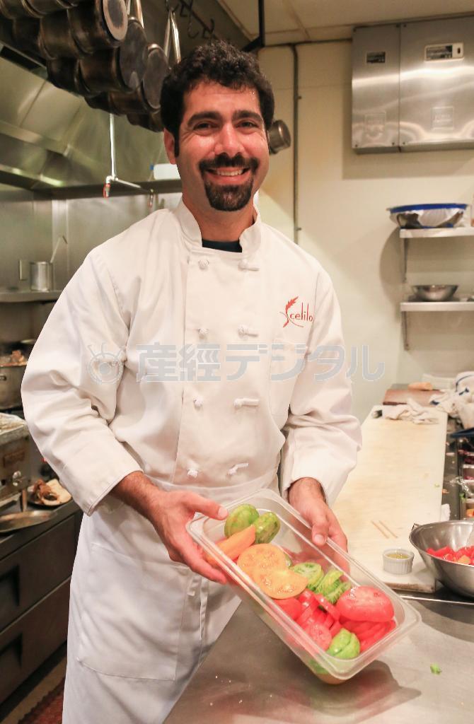 地域で収穫されたトマトを手にほほ笑む「セライロ」のオーナーでシェフのベン・スタンさん＝２０１４年１０月２３日、米オレゴン州ポートランド（緑川真実さん撮影）