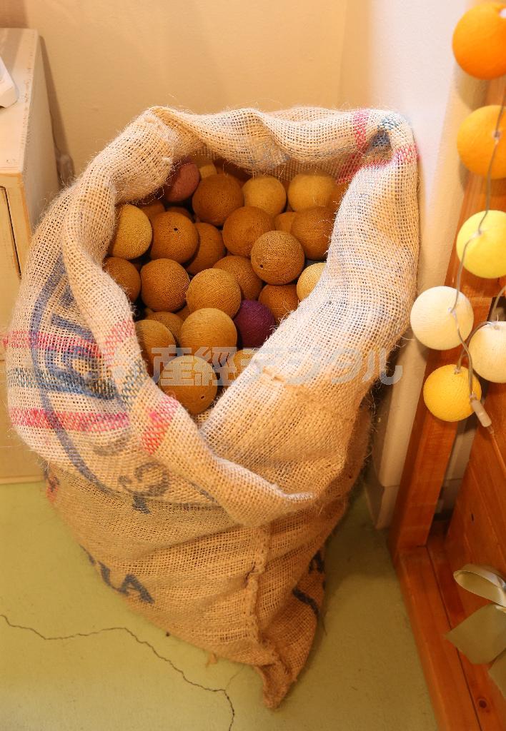 コーヒー豆のドンゴロス袋に入ったボンボラボール。照明としてではなく、置いておくだけでインテリアとしても楽しめる＝２０１４年１２月１６日、大阪市西区（寺口純平撮影）