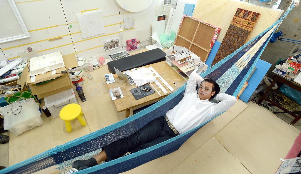 研究室につるしたハンモックで、創作の合間にくつろぐ大巻伸嗣（しんじ）さん＝２０１４年１２月９日、東京都台東区の東京芸術大（寺河内美奈撮影）
