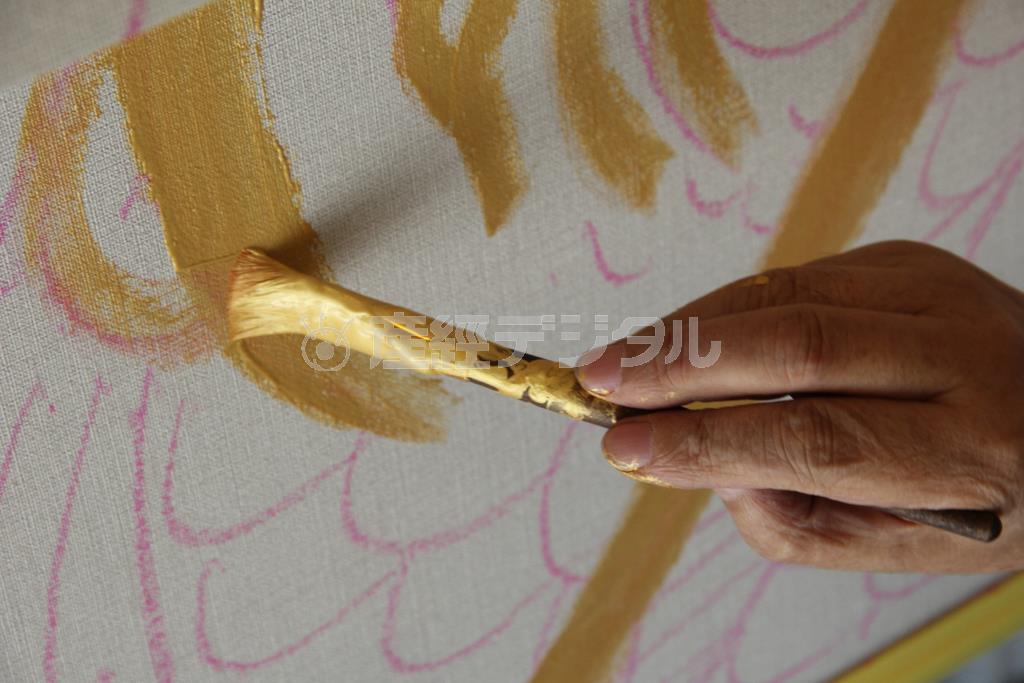 コイの下絵に金の縁取りをするキーヤン。この金を配した派手な色合いも現代の琳派（りんぱ）といわれる由縁だ＝２０１４年９月２１日（田中幸美撮影）