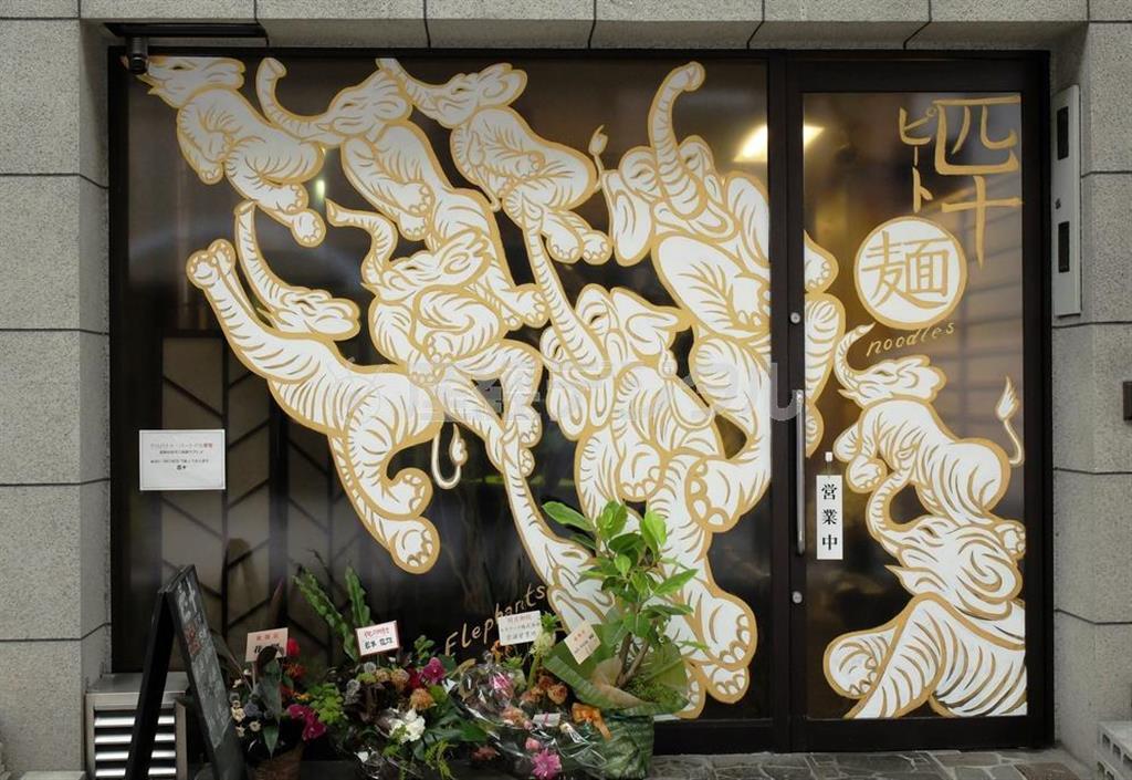 空に向かって飛翔するゾウが描かれたガラス戸。どこか琳派（りんぱ）の創始者、俵屋宗達が杉戸に描いたゾウを彷彿とさせる＝２０１４年８月１５日、京都市中京区の担々麺専門店「麺＿匹十（ピート）」（田中幸美撮影）