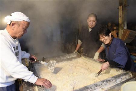 仕上げに塩をかき混ぜて水分を飛ばす百木智恵子さん（右）と次男の良太さん（中央）。母から息子へと、「とっておきの塩」が受け継がれていく＝２０１４年１２月２０日、三重県伊勢市（塩塚夢撮影）