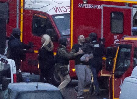 ９日、パリ東部の立てこもり現場で、ユダヤ系食料品店から解放された人質と治安要員（ＡＰ）