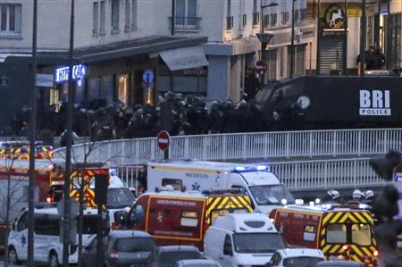 テロ容疑者が立てこもる商店を強襲する警察官ら＝９日、パリ（ＡＰ）