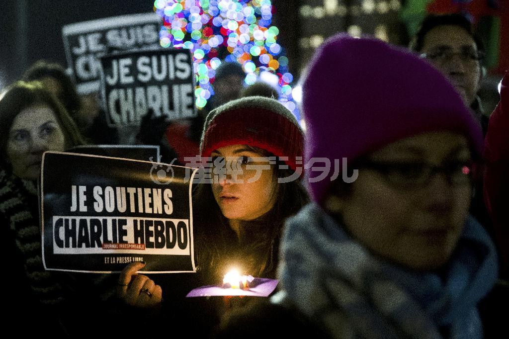 犠牲者の追悼とテロに屈しない姿勢を意味する「私はシャルリー」の標語は世界に広がった。米ペンシルバニア州フィラデルフィアで追悼のろうそくを掲げる人々＝２０１５年１月９日（ＡＰ）