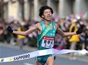 第９１回箱根駅伝の復路でゴールテープをきる青学大のアンカー、安藤悠哉＝２０１５年１月３日、東京都千代田区大手町（蔵賢斗撮影）