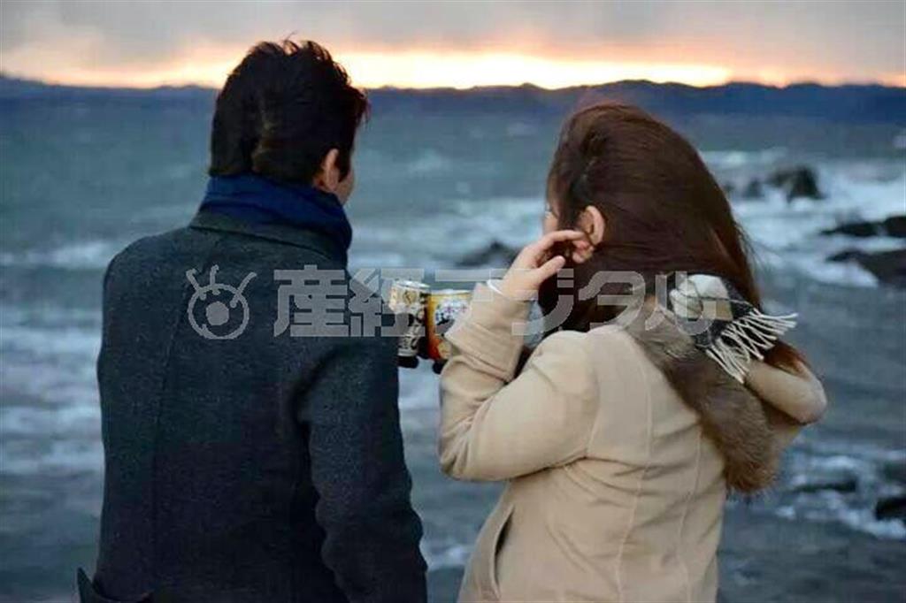 【読者写真（今回の読者：神奈川県横須賀市、平沢隆司さん）】初日の出を見るカップルが缶コーヒーで乾杯をしている、なんともほほ笑ましい瞬間を初日の出をバックに、真後ろから見事に撮れていますね！少し寒さも伝わる色合いもいい感じです（提供写真）